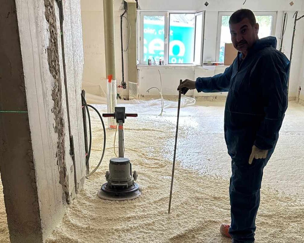 Ouvrier d'ISEO projection qui mesure la hauteur de la mousse polyuréthane qu'il a projeté sur le sol d'une maison à Ringel